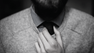 man fixing his tie