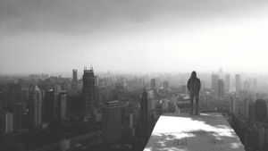 man standing on roof of building looking at skyline