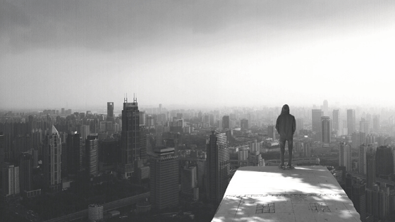 man standing on roof of building looking at skyline